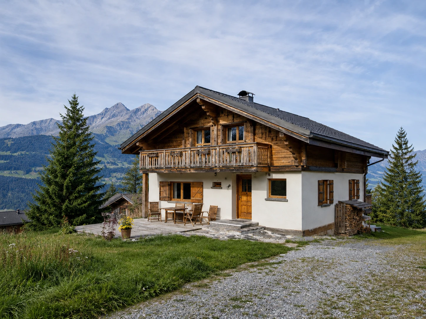Freistehendes Schweizer Chalet auf einer Bergwiese mit Blick auf die Alpen